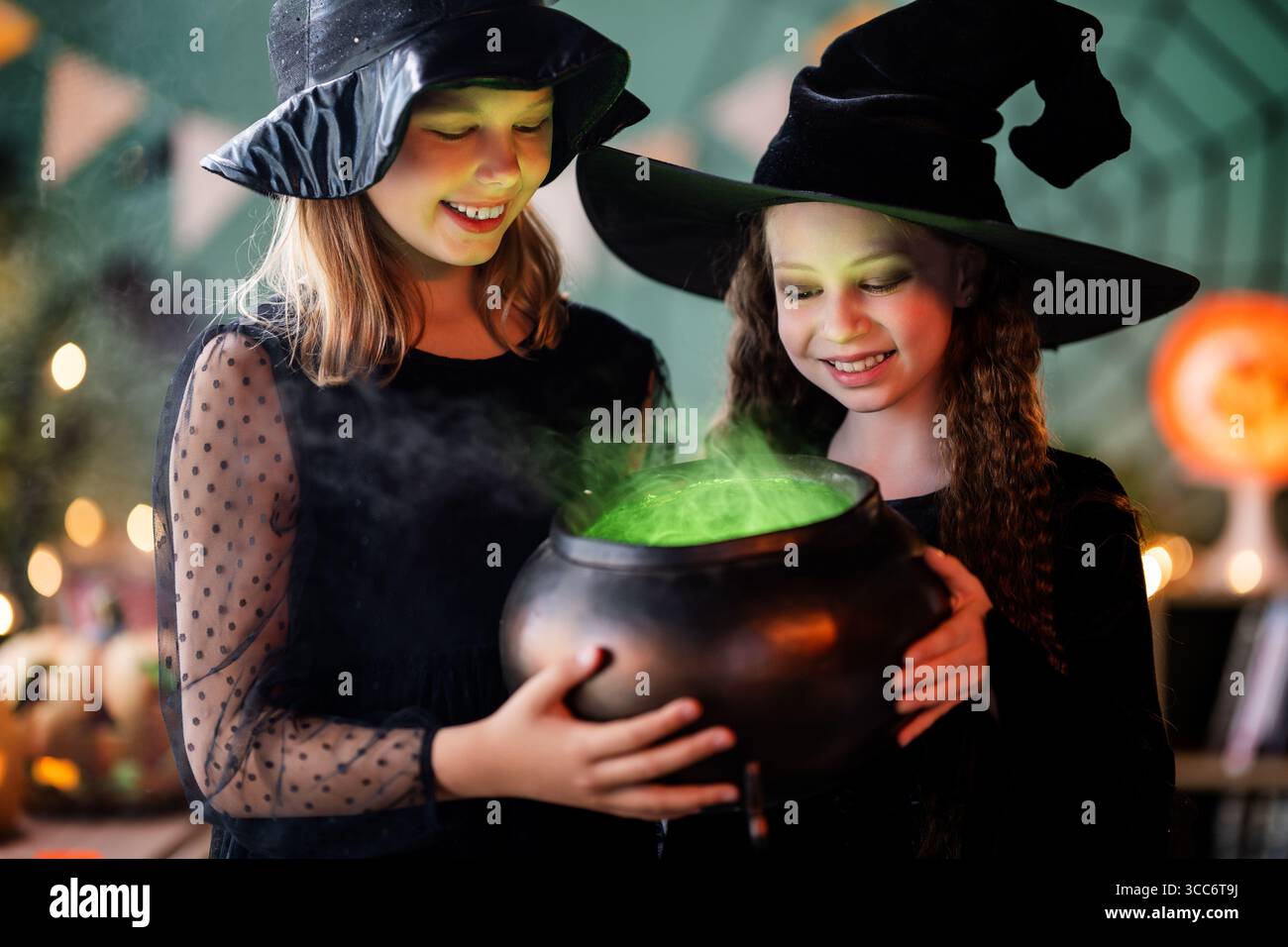 Due ragazze in costume da strega festeggiano Halloween. Bambini con erba Foto Stock