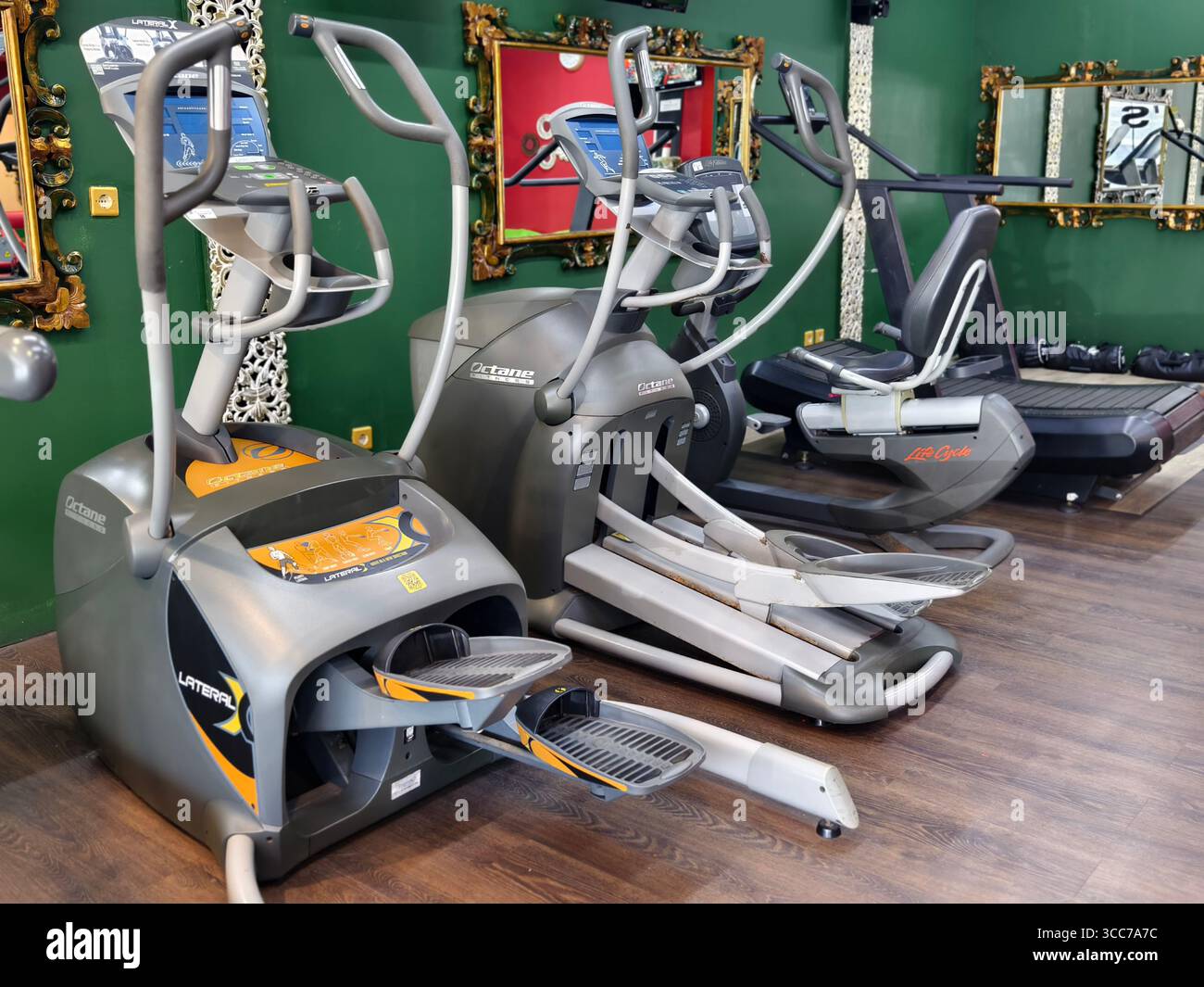 Denpasar, Bali, Indonesia - 7 agosto 2025: Moderne macchine cardio come allenatori ellittici, cyclette e tapis roulant in una palestra fitness Foto Stock