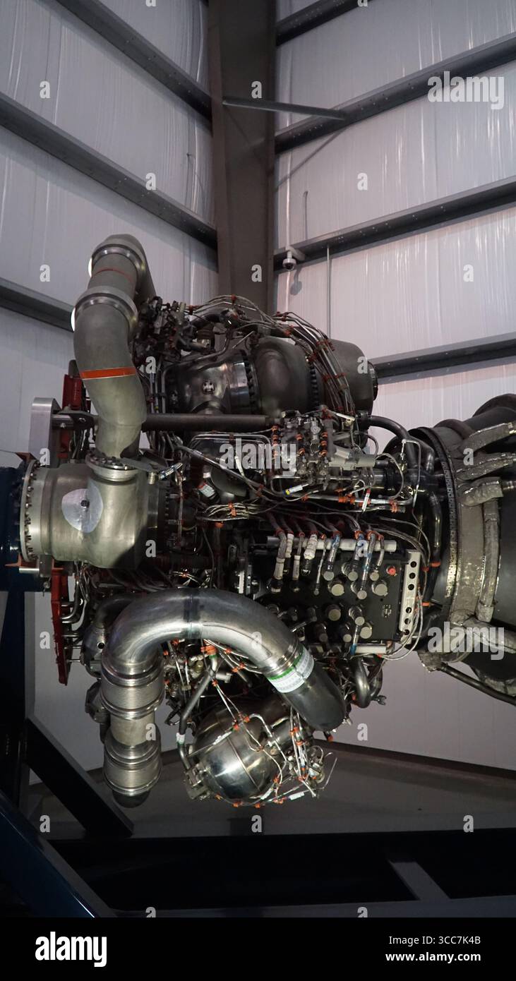Vista ravvicinata di un motore a razzo Merlin SpaceX in mostra, che mostra tubazioni complesse, valvole e macchinari turbo all'interno di una struttura aerospaziale Foto Stock