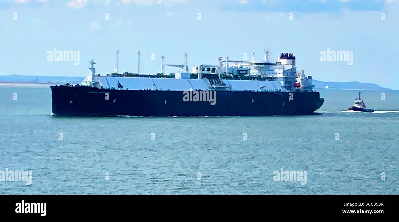 Gravelines, Francia - 18 aprile 2025: Una grande nave, seguita da un rimorchiatore, che si avvicina al porto francese di Gravelines Foto Stock