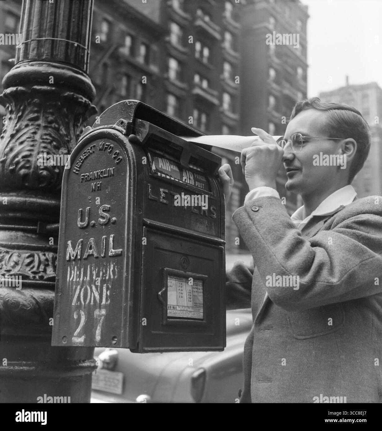 1952 foto di un uomo che postava una lettera in una cassetta postale a New York. Foto Stock