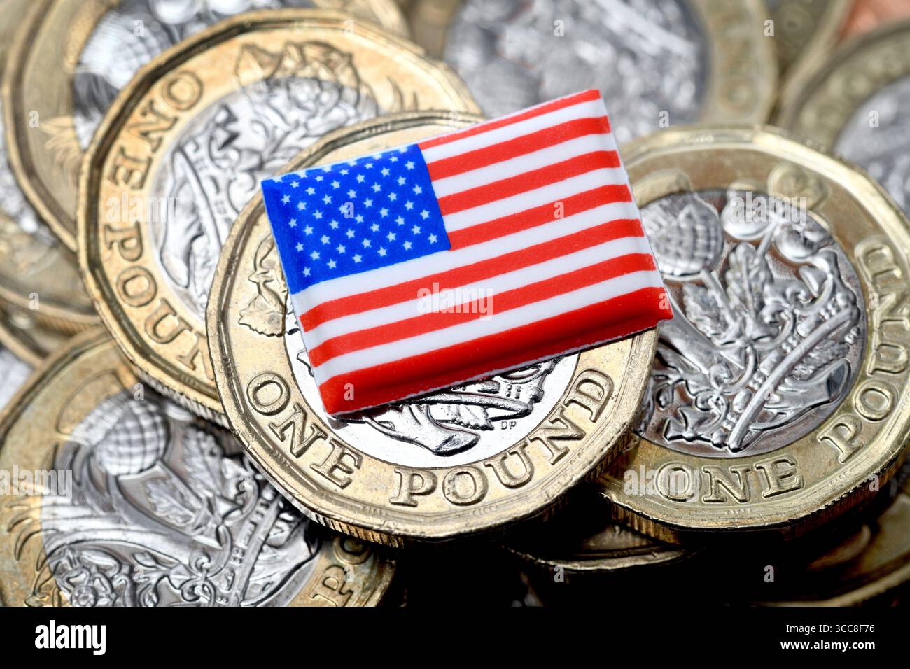 LE MONETE DA UNA STERLINA BRITANNICA CON STELLE E STRISCE AMERICANE RAPPRESENTANO LE TARIFFE USA PER IL TASSO DI CAMBIO DEL DOLLARO DELL'ECONOMIA ETC UK Foto Stock