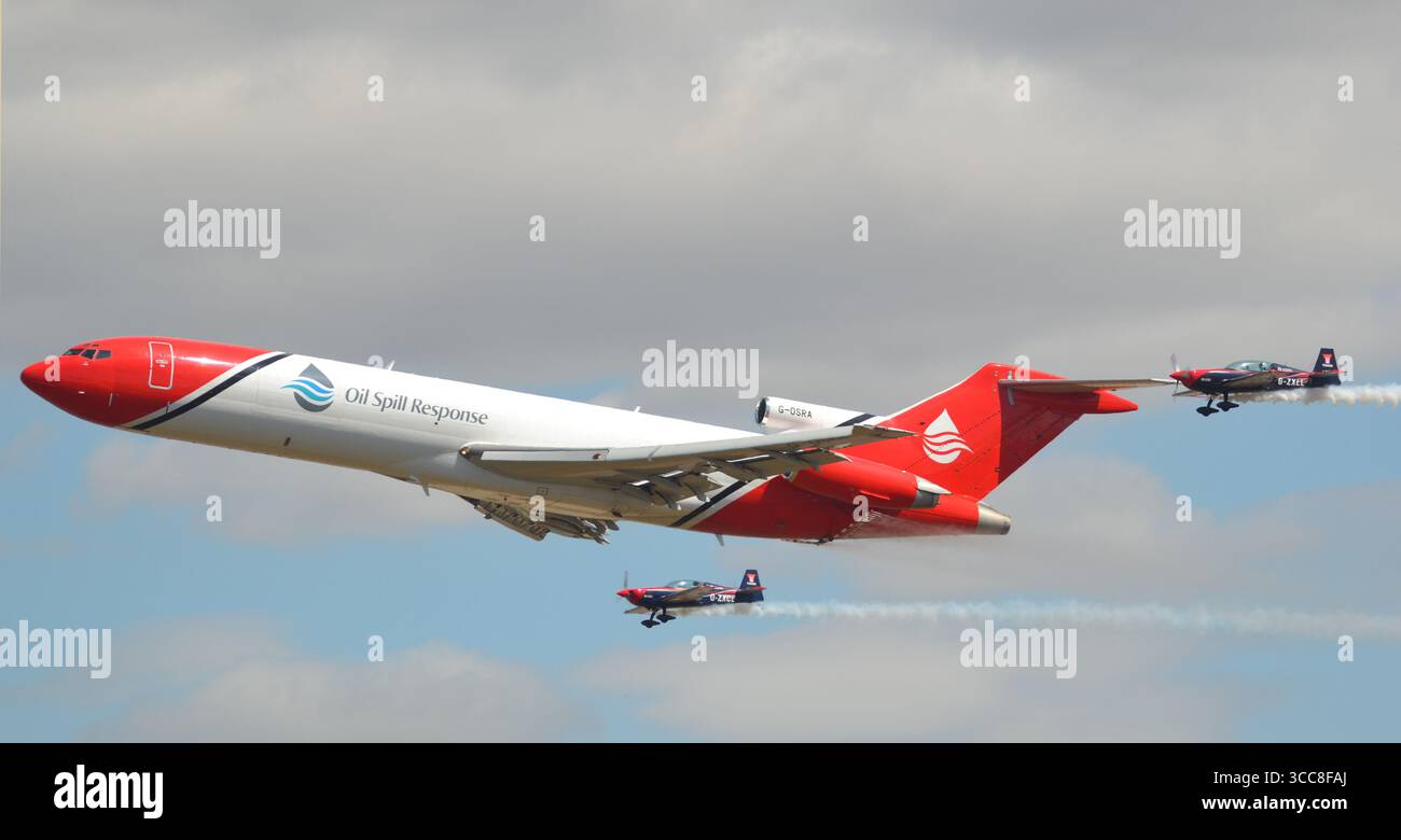Boeing 727-2S2F aereo di reazione alla fuoriuscita di petrolio in formazione con due aerei aerobatici Extra 300LP presso il Royal International Air Tattoo Foto Stock