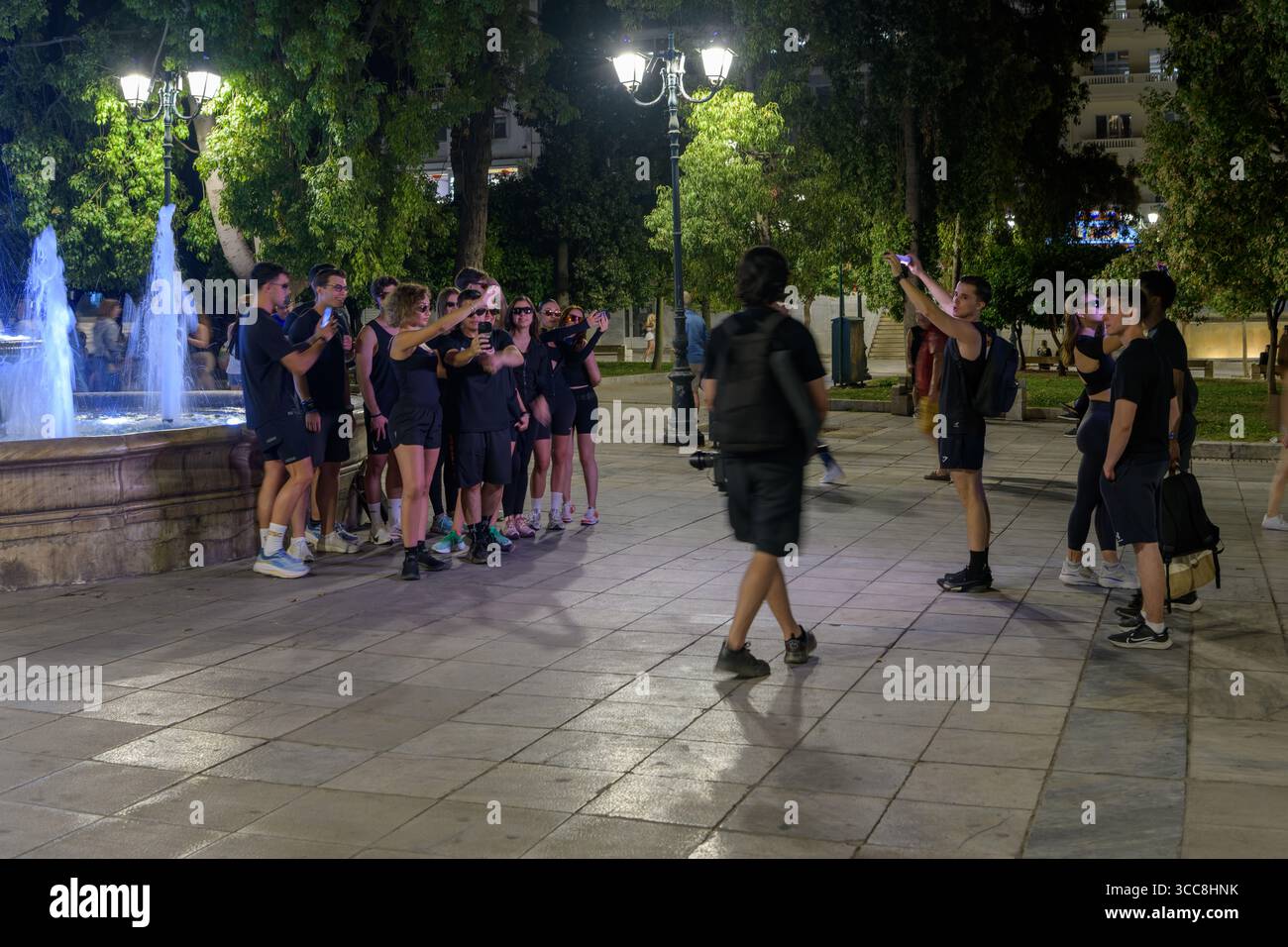 Scena notturna con persone alla Fontana nel centro di Atene, in Grecia Foto Stock