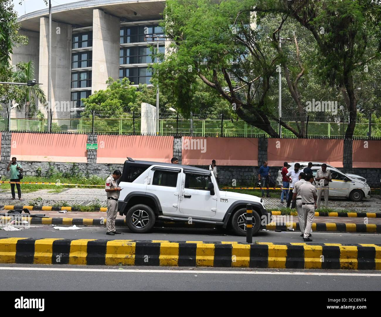 NUOVA DELHI, INDIA - 10 AGOSTO: Il personale addetto alla sicurezza sta di guardia vicino al veicolo Thar, visto sul luogo dell'incidente a Mother Teresa Crescent Marg per il parcheggio di Talkatora, il 10 agosto 2025 a nuova Delhi, India. Una persona e' stata uccisa e un'altra ferita dopo essere stata investita da un SUV su Mother Teresa Road. La polizia ha detto che l'auto, Mahindra Thar, ha colpito i pedoni vicino a Gyarah Murti domenica mattina. Durante l'indagine, la polizia ha recuperato una bottiglia di liquore dal veicolo, a seguito della quale una squadra forense è stata chiamata ad esaminarla per determinare se il consumo di alcol fosse coinvolto. (Pho Foto Stock
