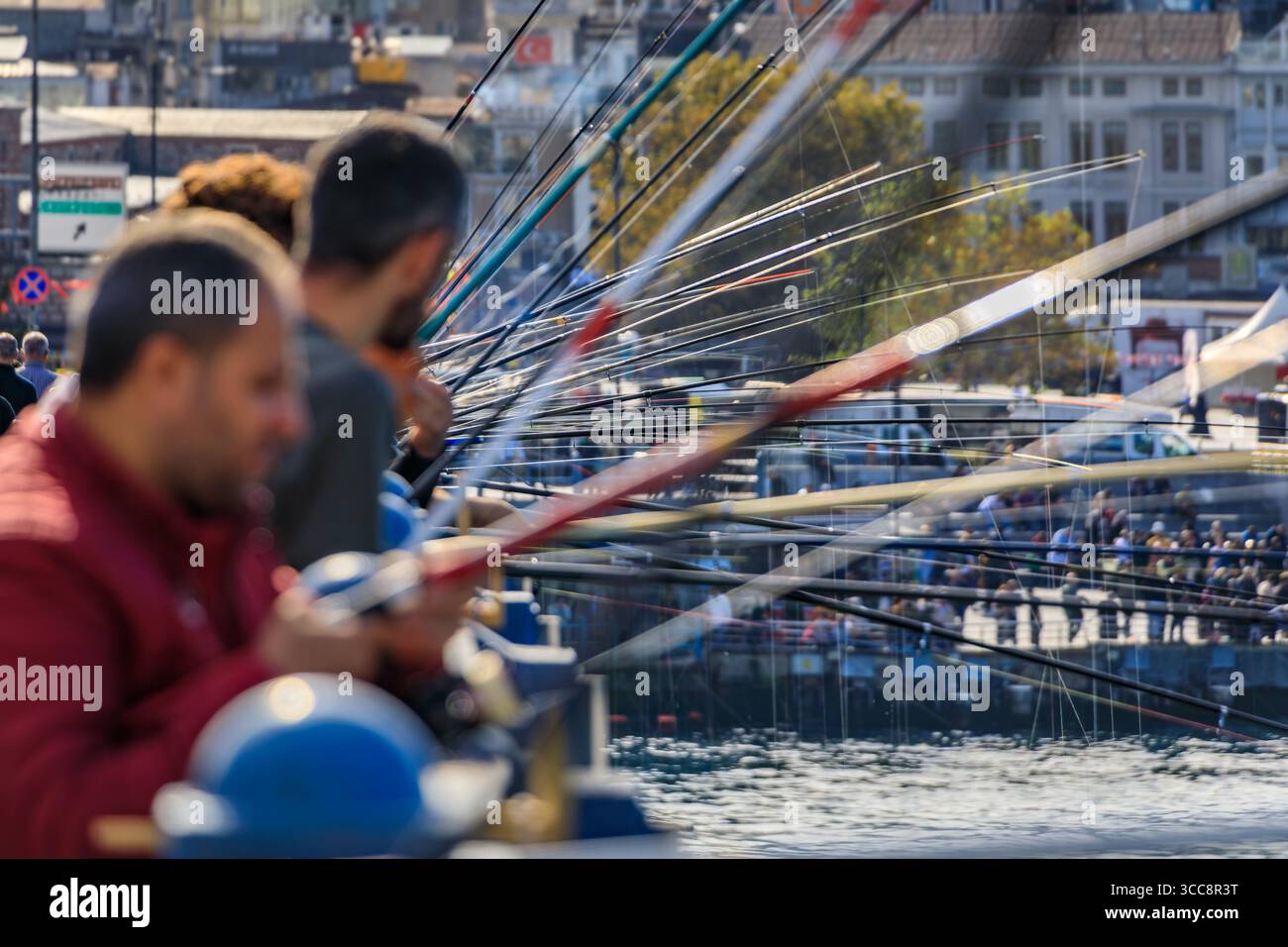 Pescatori sul ponte Galata, un passatempo popolare di Istanbul, Turchia, una sfocatura stilizzata di più canne da pesca crea un primo piano astratto unico Foto Stock