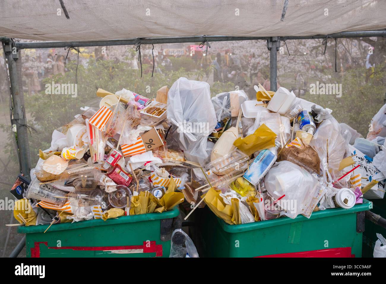 I rifiuti di imballaggio di plastica e cibo traboccano di bidoni della spazzatura durante la stagione di osservazione dei fiori di Hanami Sakura al Parco Maruyama, Gionmachi Kitagawa, Higashiyama Foto Stock