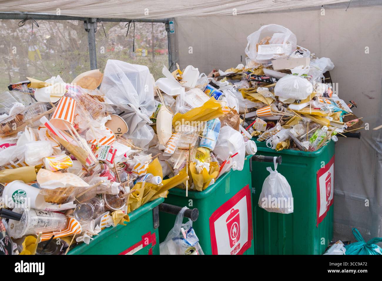 I rifiuti di imballaggio di plastica e cibo traboccano di bidoni della spazzatura durante la stagione di osservazione dei fiori di Hanami Sakura al Parco Maruyama, Gionmachi Kitagawa, Higashiyama Foto Stock