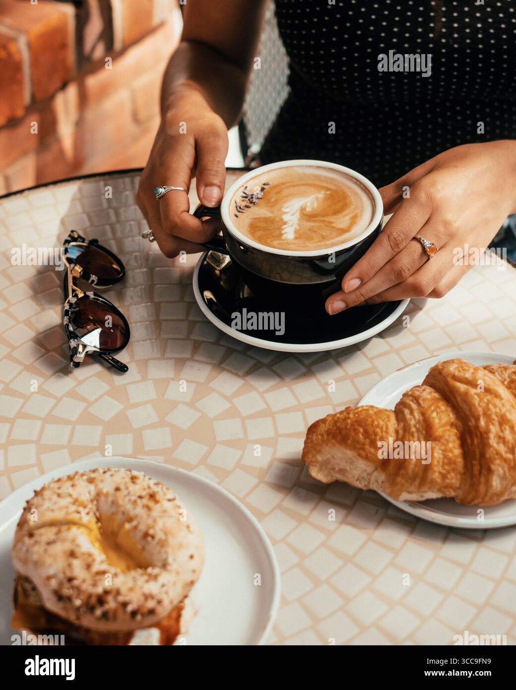 Donna che tiene il latte con latte Art e lavanda Foto Stock