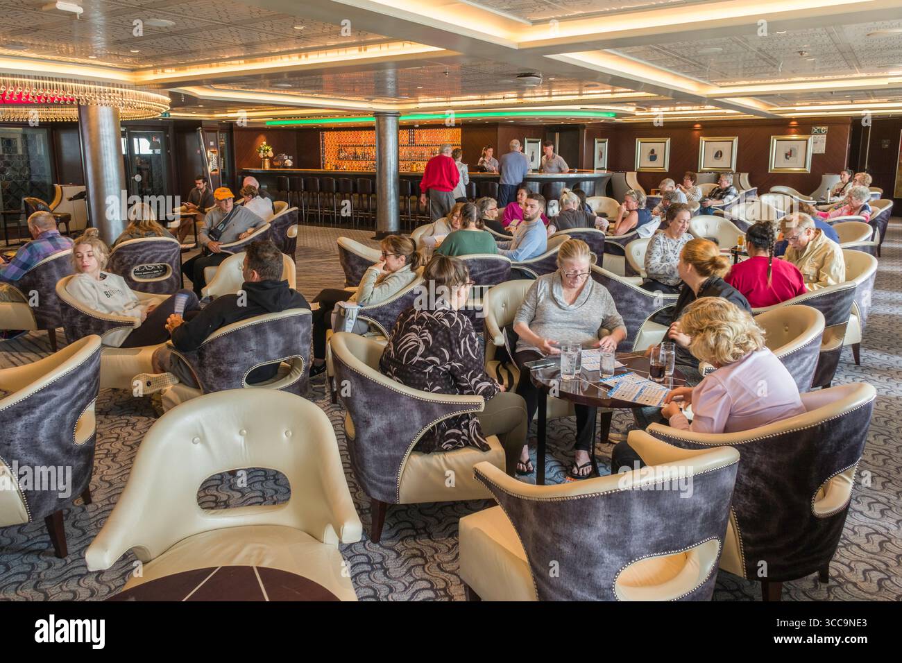 Passeggeri seduti nella Explore Lounge sul ponte 4 giocando a Bingo, nave da crociera Seven Seas Explorer Foto Stock