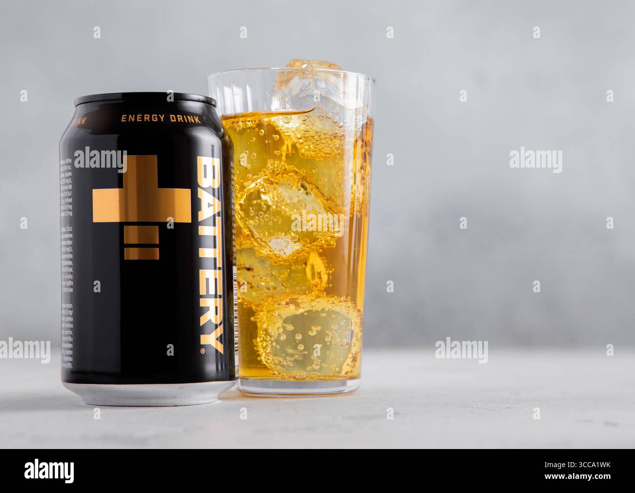 LONDRA, Regno Unito - 01 AGOSTO 2022: Battery Plus Energy drink con bicchiere e cubetto di ghiaccio sul tavolo leggero. Foto Stock