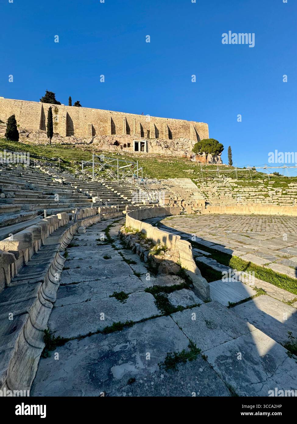 Antico teatro di Dioniso, posti a sedere in pietra e rovine con sfondo sulla collina dell'Acropoli ad Atene - Immagine stock catturata con smartphone
