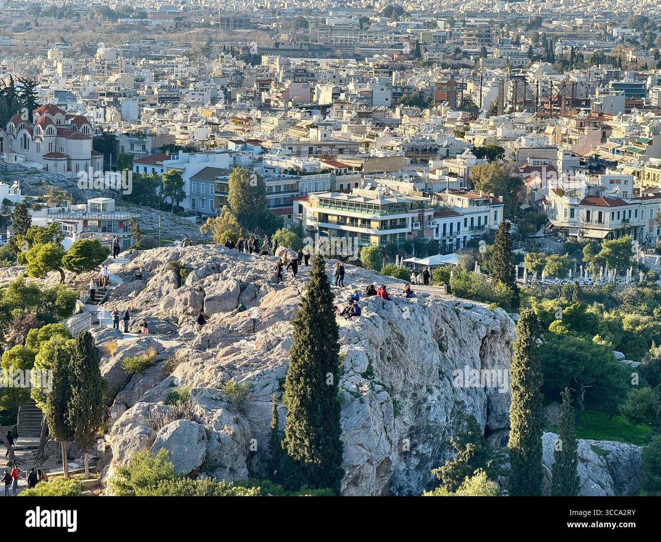 Vista della collina di Areopago con gente che esplora, affacciata sul paesaggio urbano di Atene, Grecia. - Immagine stock catturata con smartphone