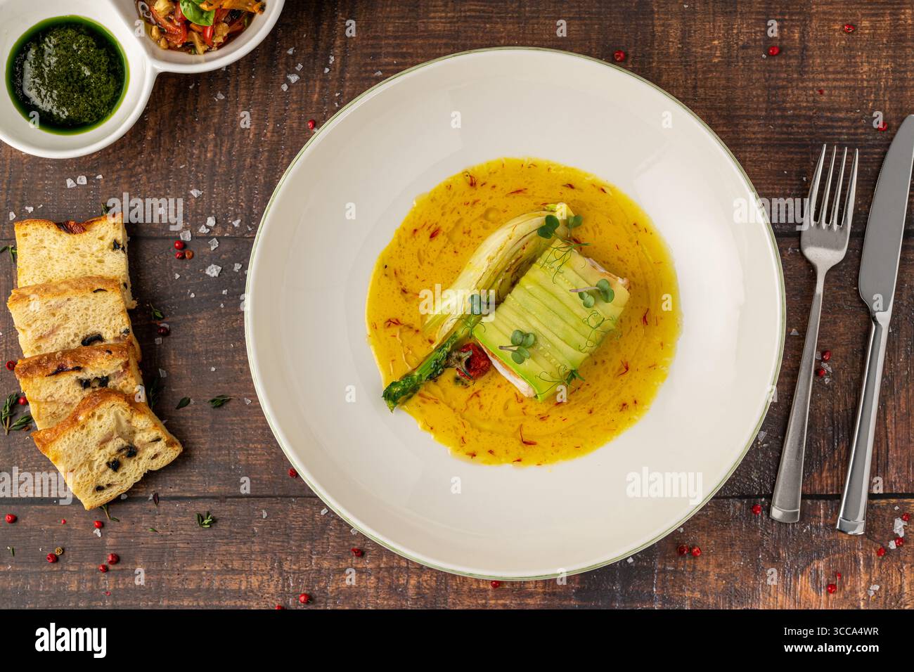 Filetto di pesce ricoperto di zucchine in salsa gialla allo zafferano Foto Stock