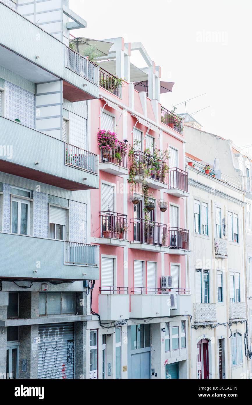 Edificio di appartamenti rosa con balconi e fiori a Lisbona Foto Stock