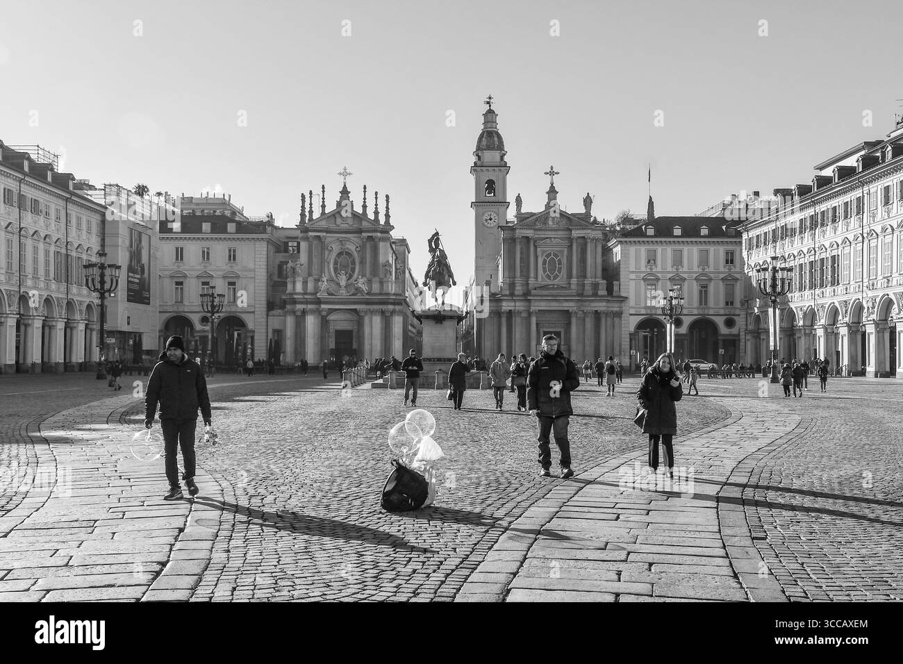B&W Piazza San Carlo con le cosiddette "chiese gemelle": Santa Cristina (a sinistra) e San Carlo Borromeo, e un venditore ambulante, Torino, Piedmot, Italia Foto Stock
