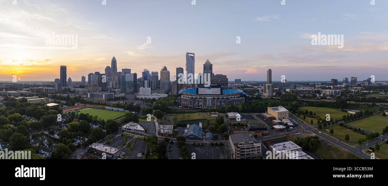 Charlotte, Stati Uniti - 30 luglio 2025: Vista aerea dello skyline della città sotto un cielo pastello, con il Bank of America Stadium annidato tra gli edifici. Foto Stock