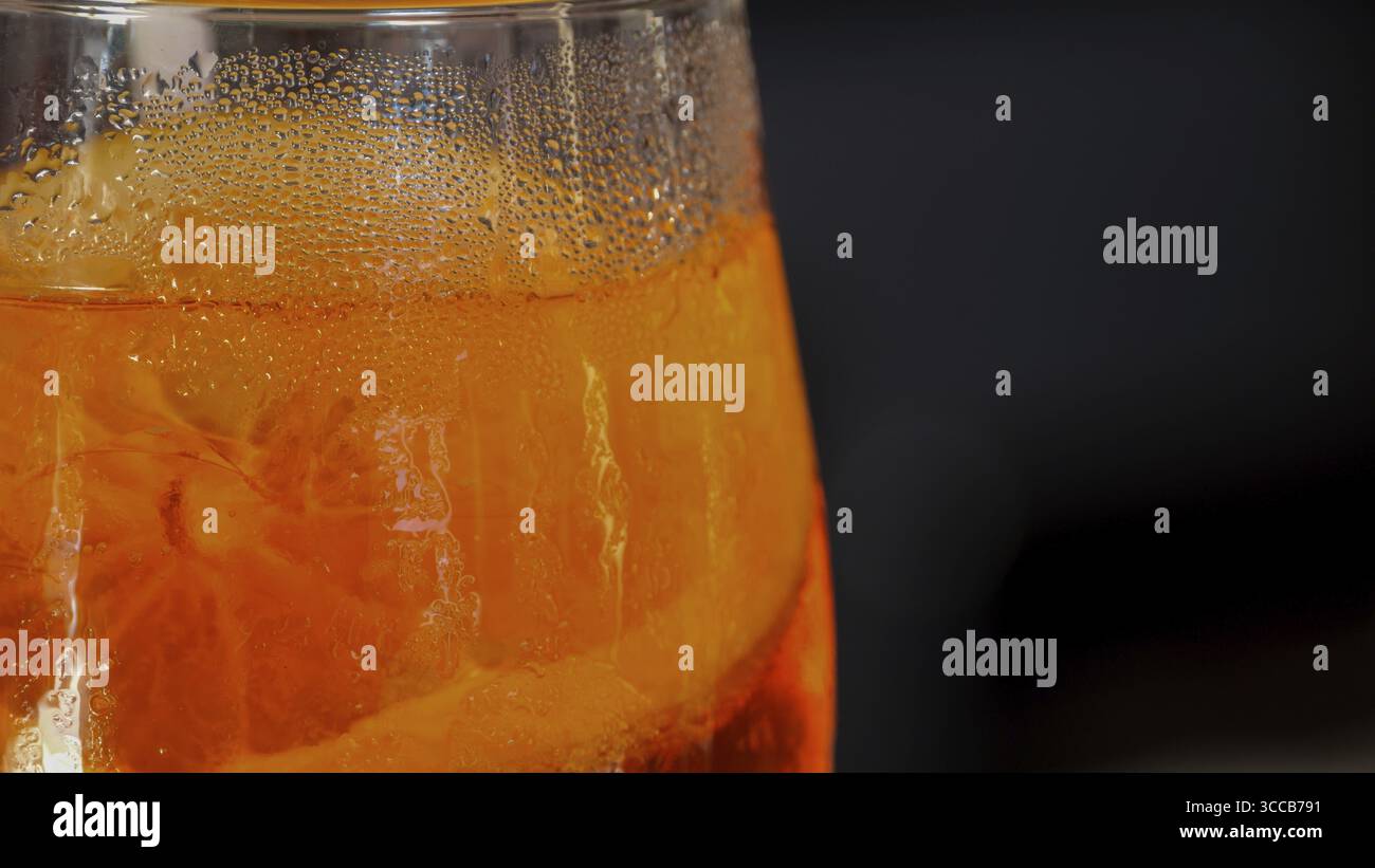 Cocktail Spritz rinfrescante con fette di arancia fresca, bollicine e ghiaccio, perfetto per il divertimento del tempo caldo e per le vivaci feste da bar Foto Stock