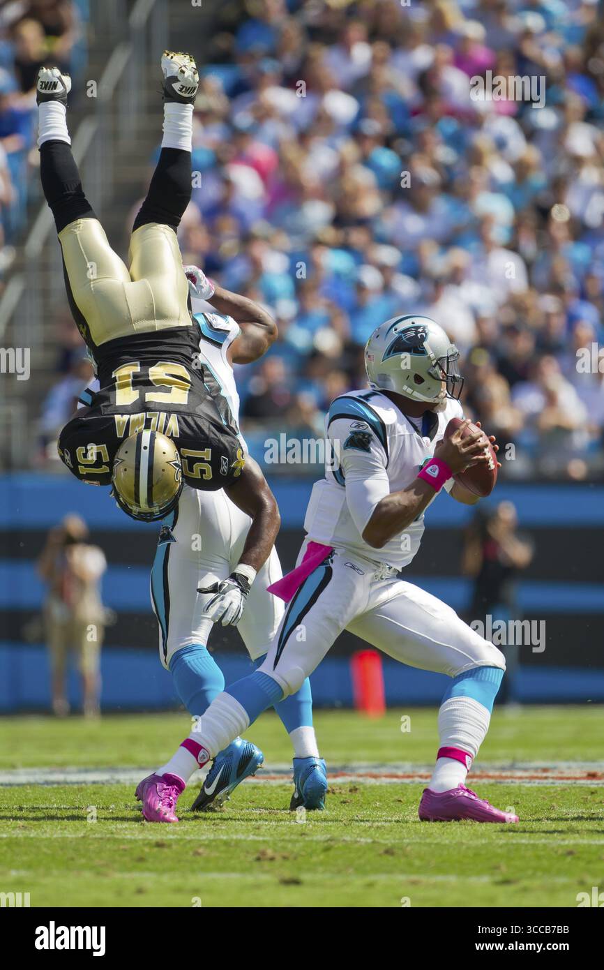 CHARLOTTE, NC - 09 ottobre 2010: Saints Linebacker, Jonathan Vilma, viene capovolto mentre Panthers Quaterback, Cam Newton, si prepara a passare come Panthers pla Foto Stock