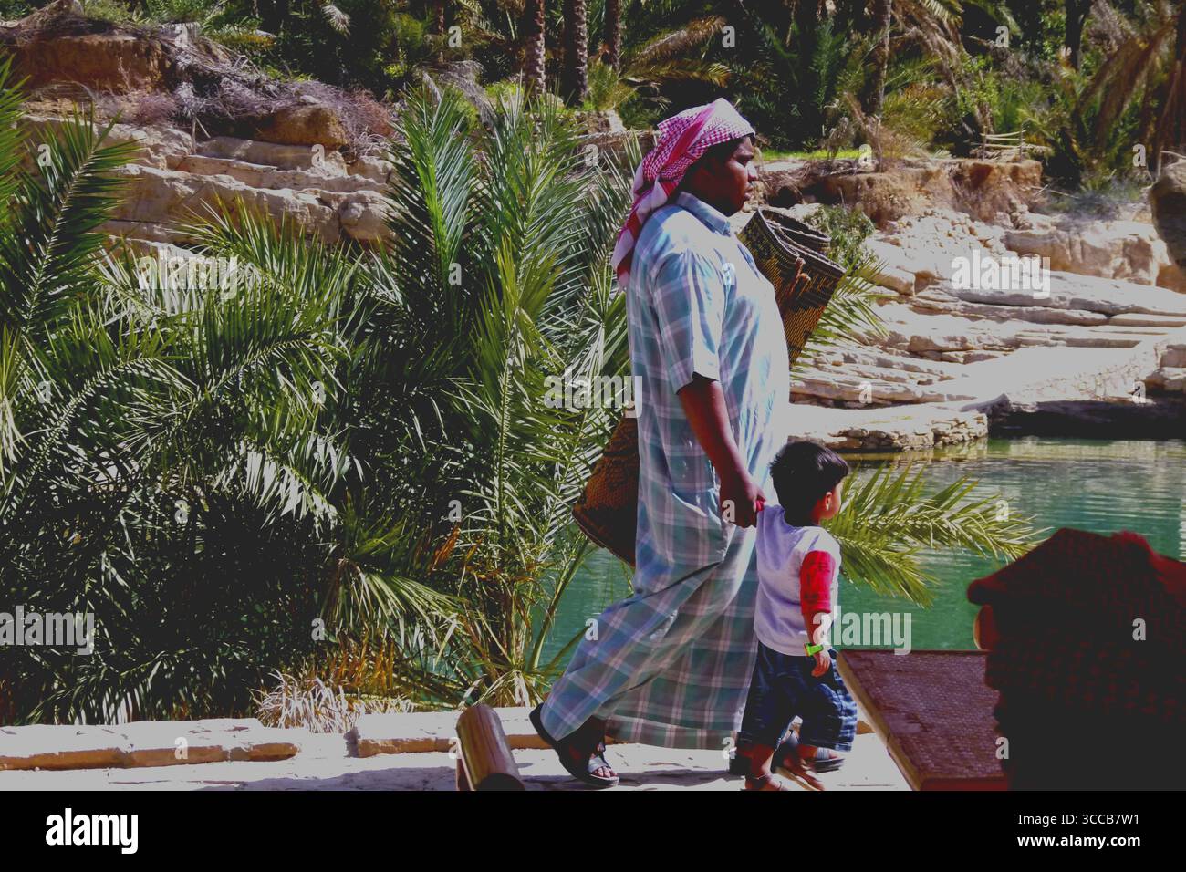 Uomo del posto con figlio sulla strada per un picnic, Oman Foto Stock
