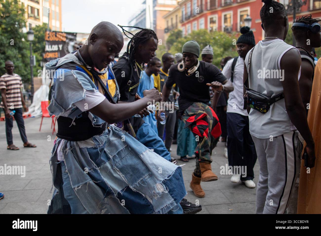 Gli uomini eseguono danze tradizionali durante la celebrazione. I residenti senegalesi a Madrid hanno celebrato apertamente il Gran Magallo di Touba del 2025 con i residenti di Lavapies. Quest'anno, si celebrerà il 13 agosto, corrispondente al 18° giorno di Safar nel calendario islamico. Il Gran Magallo di Touba è la più importante festa religiosa della Fratellanza Mouride in Senegal, un ramo dell'Islam sufi. Viene celebrato ogni anno nella città di Touba per commemorare la vita e gli insegnamenti del suo fondatore, Cheikh Ahmadou Bamba. Foto Stock
