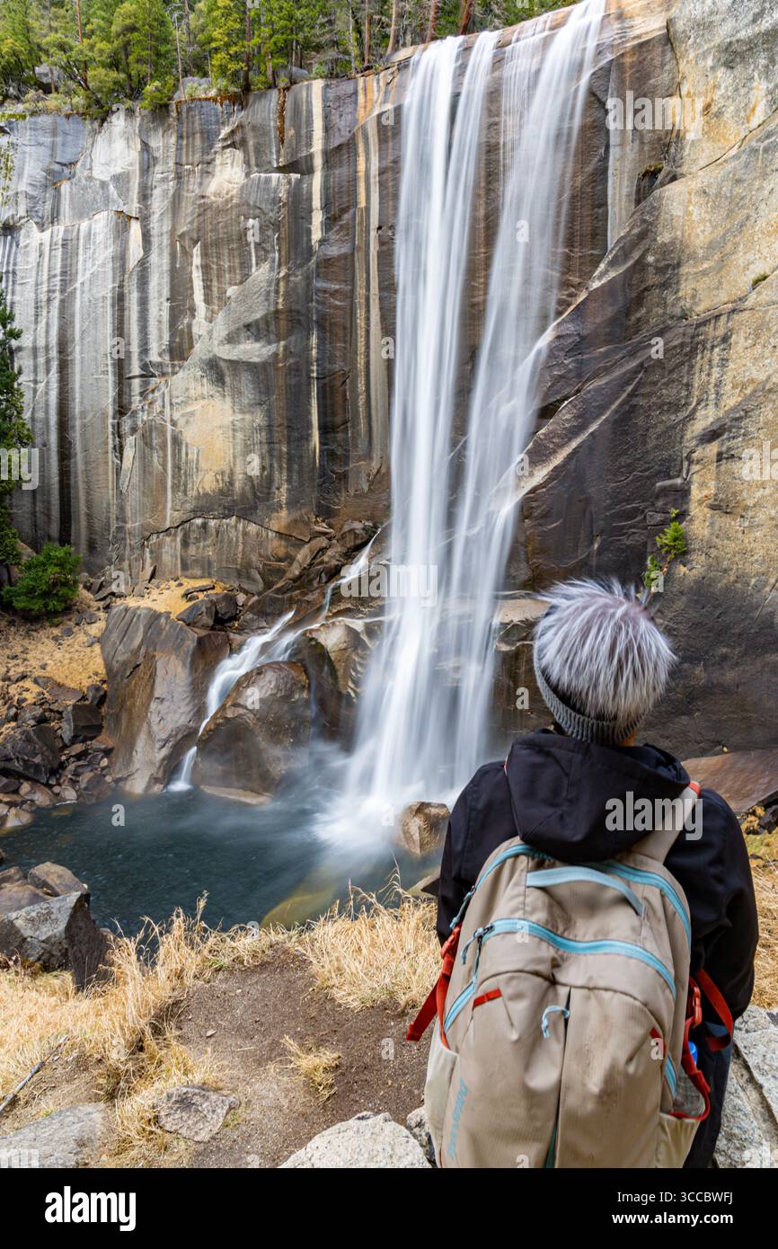 Escursionista femminile presso la cascata di montagna del Parco Nazionale di Yosemite, California, Stati Uniti Foto Stock