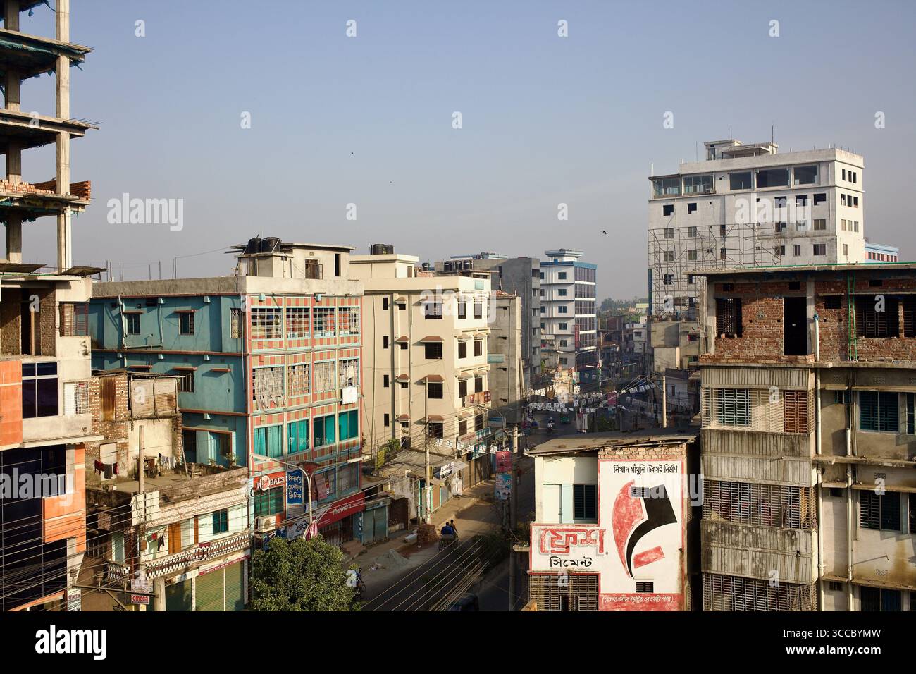 Skyline di Bogra, Bangladesh, che mostra edifici di media altezza, segnaletica commerciale e sviluppo urbano in costruzione. Foto Stock