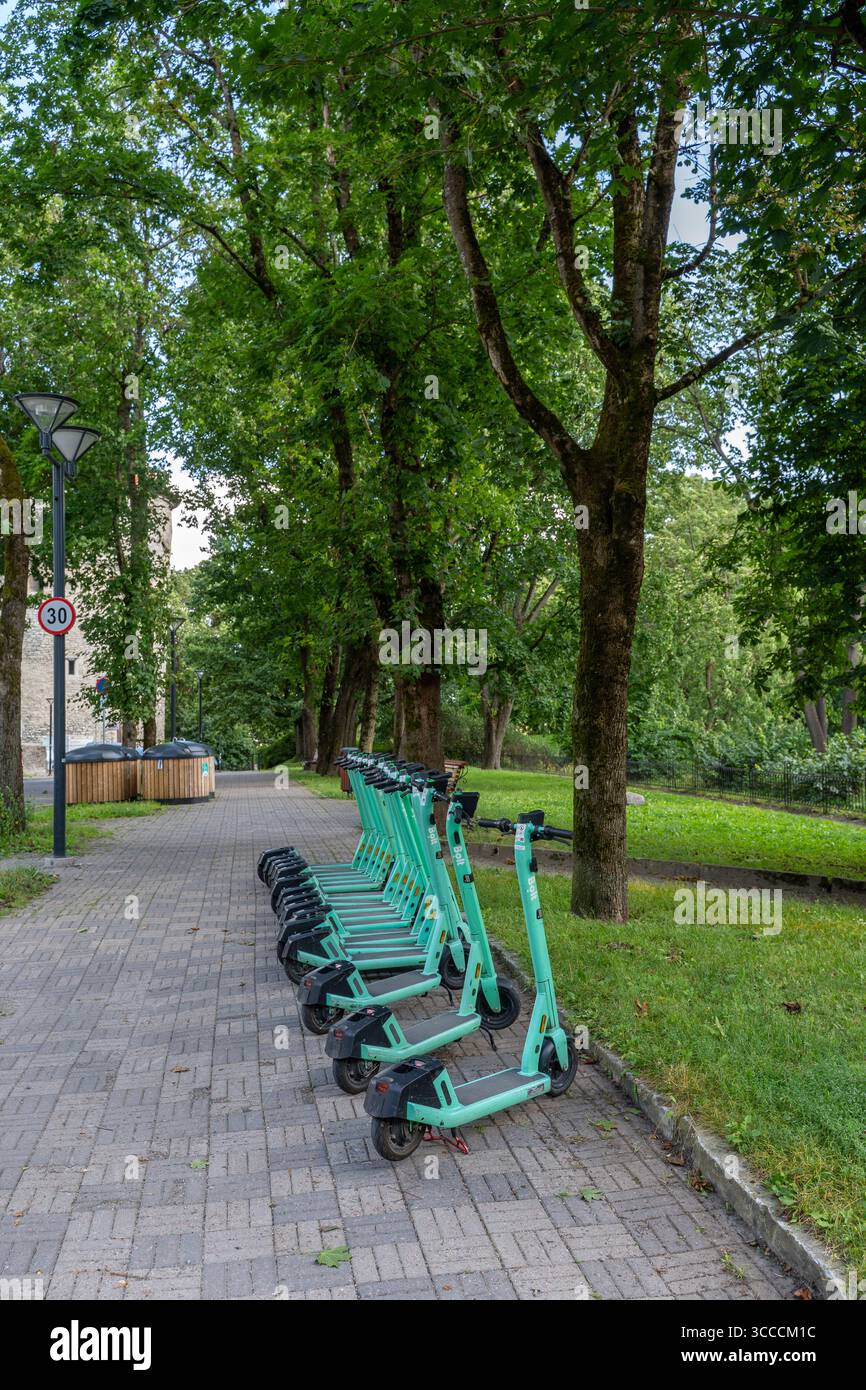 Noleggio scooter elettrici Row of Bolt parcheggiati lungo un sentiero pedonale in un parco. Foto Stock