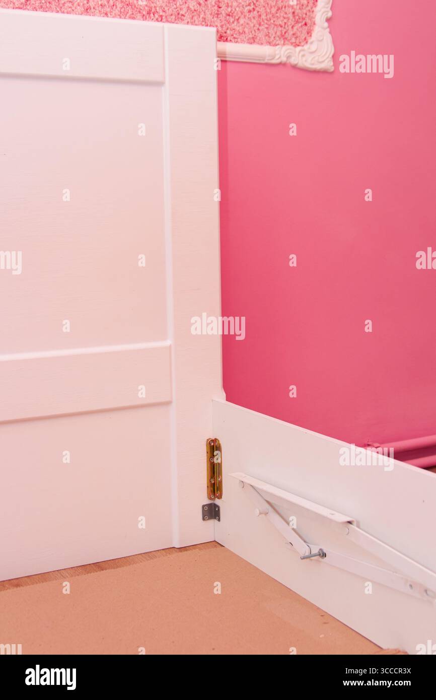 assemblare un letto in una stanza rosa Foto Stock
