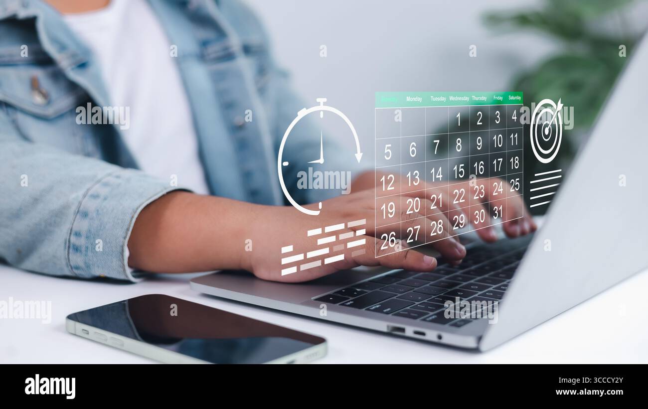 Persona che utilizza un notebook con calendario digitale, orologio e icone di destinazione sovrapposte, simboleggiando un'efficace gestione del tempo, pianificazione strategica, definizione degli obiettivi, A. Foto Stock