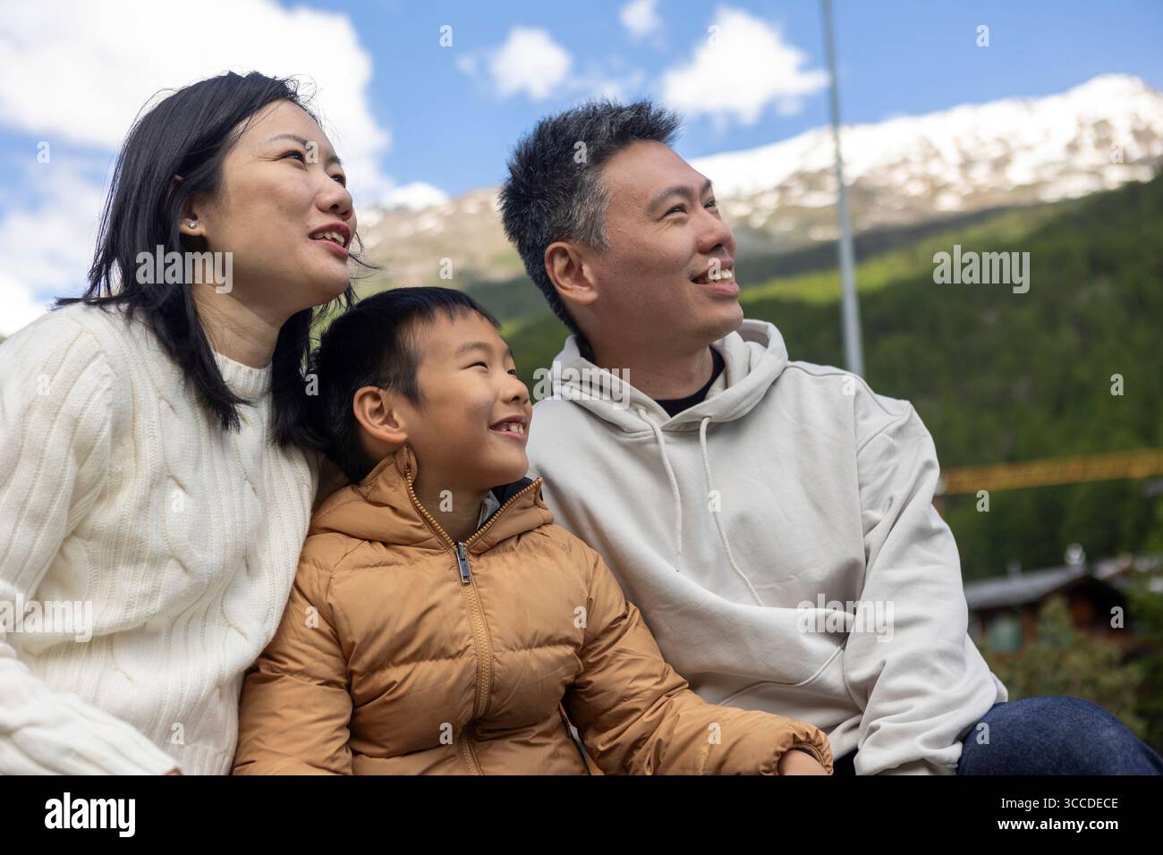 Sorridente famiglia asiatica che guarda le montagne e si gode la vacanza insieme Foto Stock