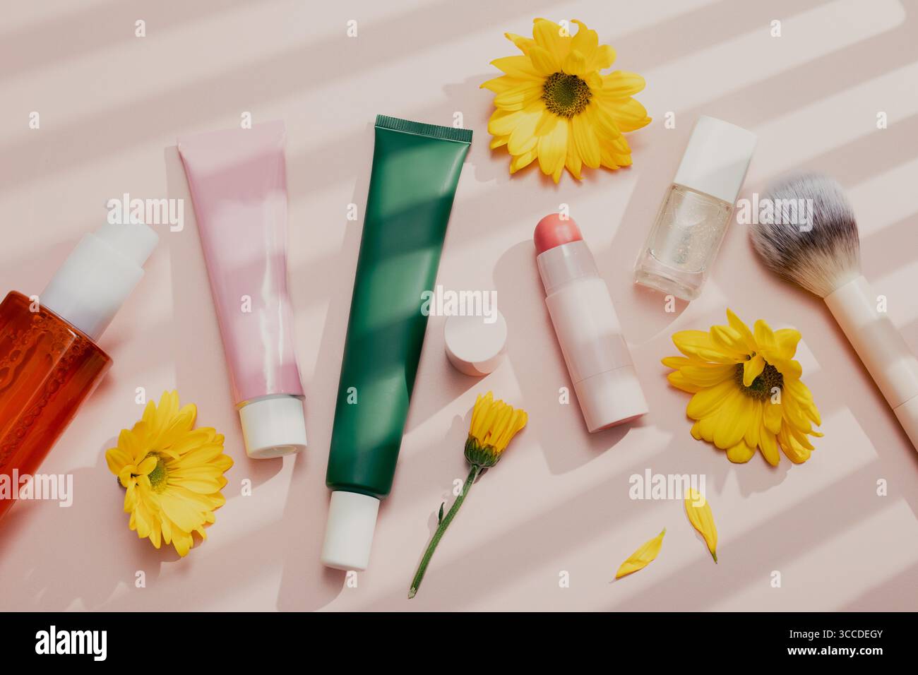 Prodotti di bellezza piatti con crema idratante, olio detergente, lozione e articoli per il trucco su sfondo rosa pastello pieno di ombre, nostalgico retro aesthe Foto Stock