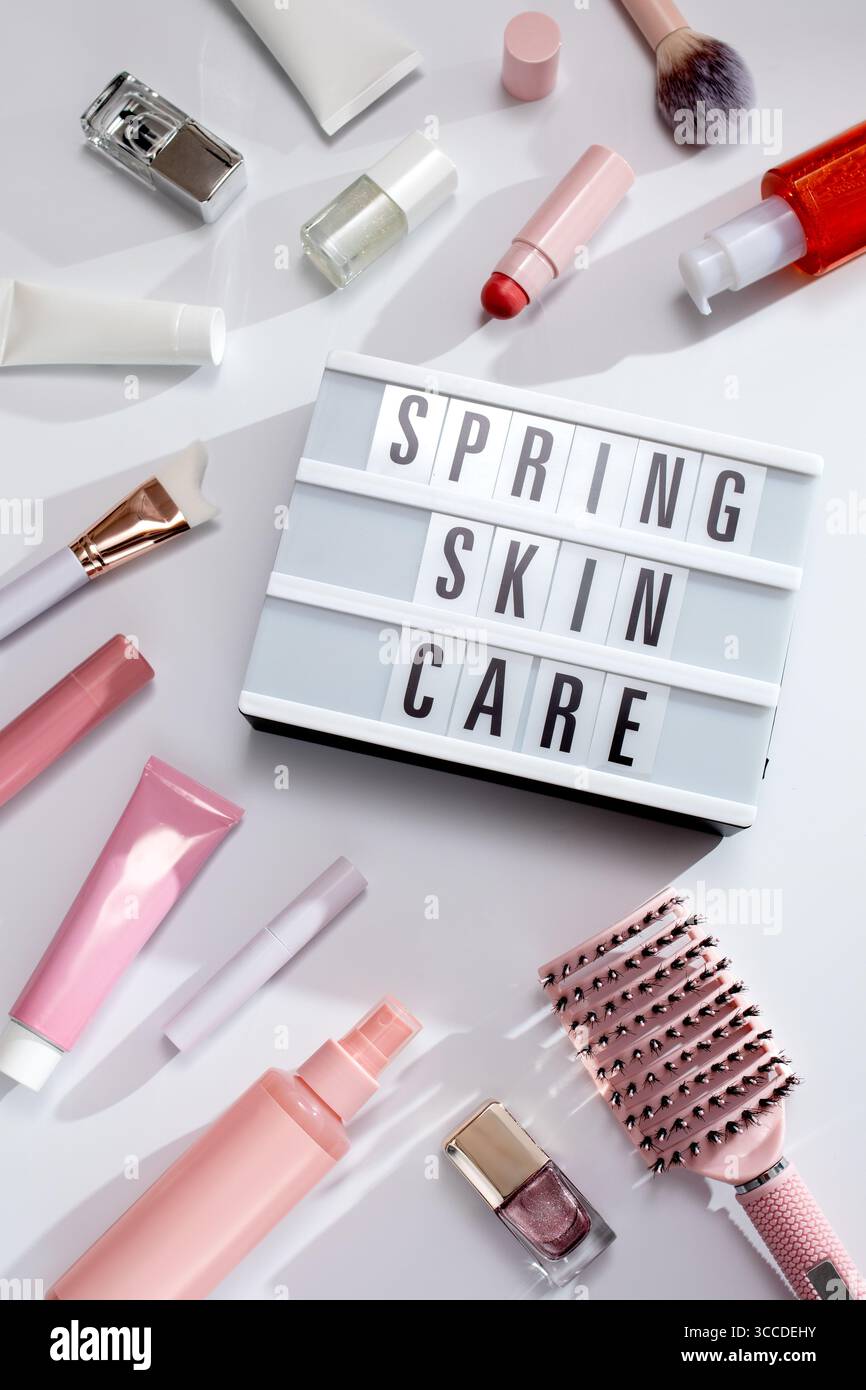 I prodotti di bellezza incorniciano lo sfondo piatto con citazione primaverile per la cura dei capelli e articoli per il trucco su sfondo bianco pieno di ombre, nostalgico retr Foto Stock
