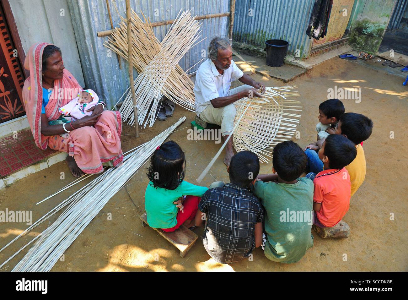 25 novembre 2022: 26 novembre 2022. Sylhet, Bangladesh: Moyna Biswas 80 anni, un'artista artigianale di canna da zucchero di Haripur, nell'area di Sylhet, sta tessendo un prodotto di canna mentre i suoi eredi stanno osservando e imparando accanto a lui. Egli è certo che il suo erede non prenderà questo lavoro artigianale di canna da zucchero come professione, mentre i prodotti di plastica sono disponibili sul mercato a un prezzo inferiore a quello della canna da zucchero e peggiorano già il mercato. (Immagine di credito: © MD Rafayat Haque Khan/ZUMA Press Wire) Foto Stock