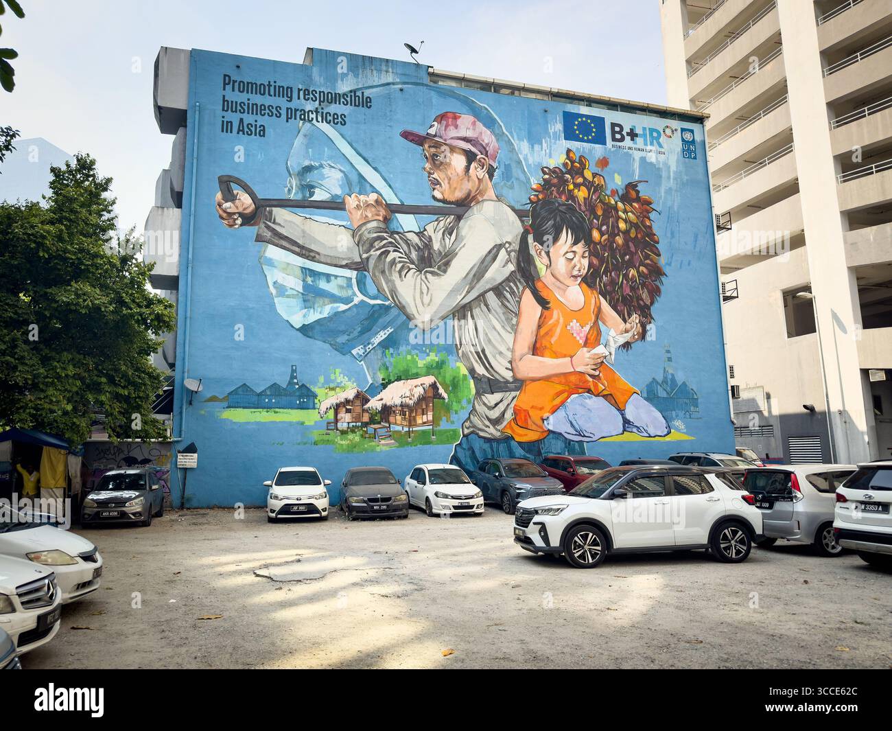 Vivace arte murale su un grande muro di edifici che mostra un uomo e una ragazza che tengono fiorentepromuovere pratiche commerciali responsabili in Asia, kuala lumpur, malesia - Immagine stock catturata con smartphone