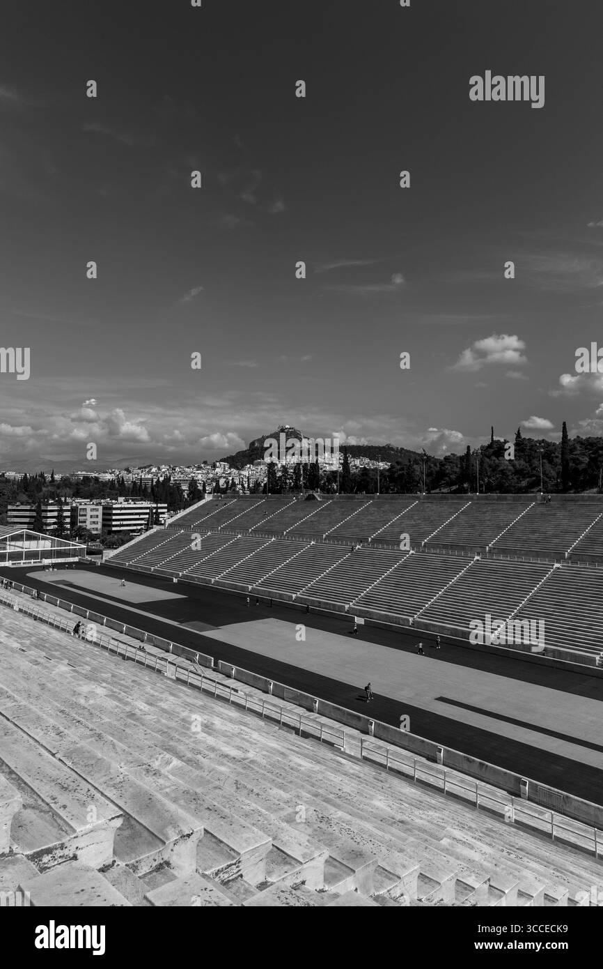 Stadio Panatenaico con la lussureggiante collina di Licabetto sullo sfondo, catturato sotto il cielo limpido ad Atene, in Grecia, evidenziando la storica ma Foto Stock