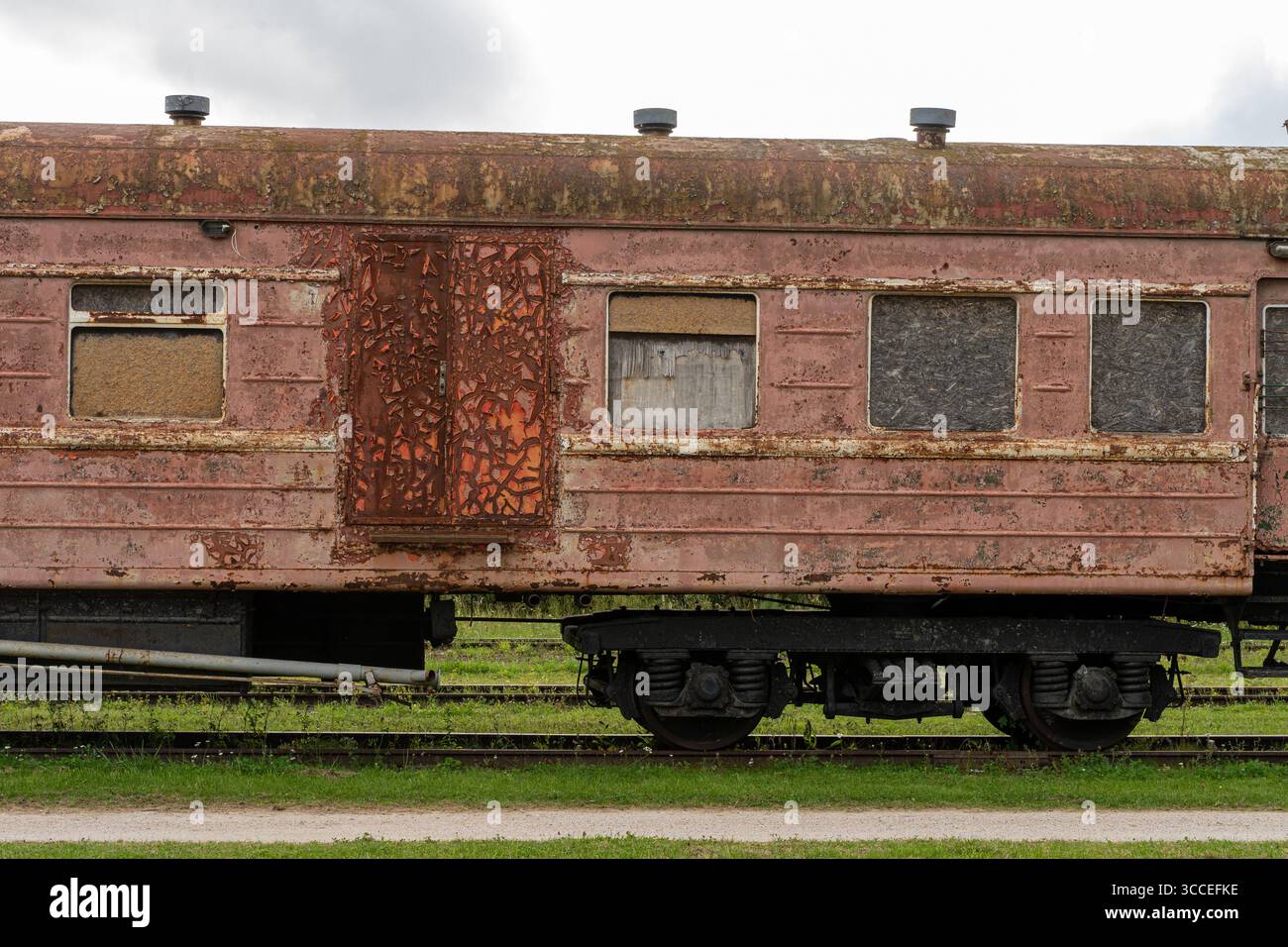 10. Agosto 2025, Estonia. Vista laterale di un vecchio vagone ferroviario abbandonato con vernice ruggine e sbucciatura. Foto Stock