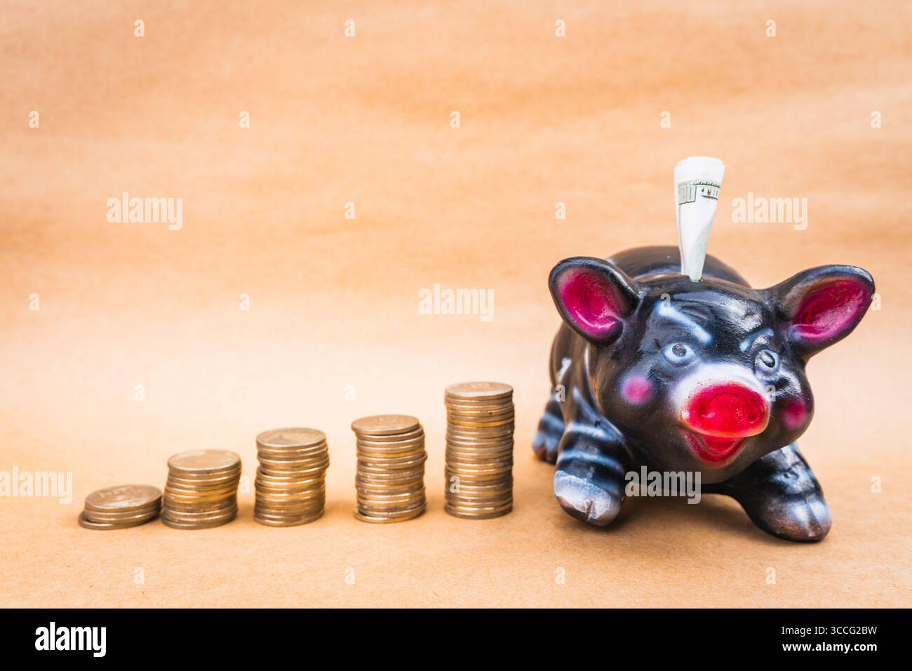 Maiale nero, realizzato a mano, che cresce le monete, con fondo pieno Foto Stock