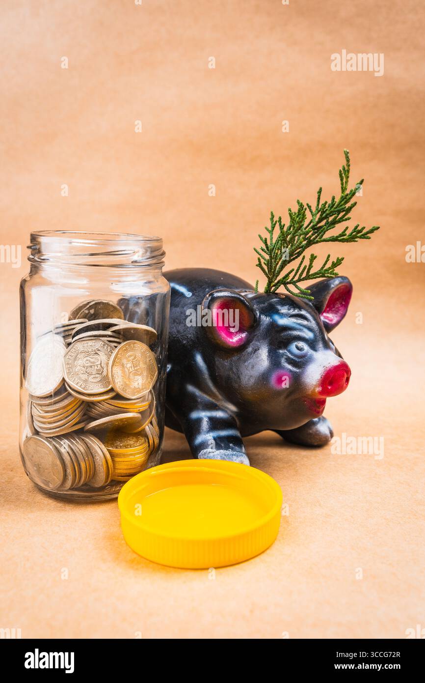 Risparmio e crescita maiale e monete in un vaso con fondo pieno Foto Stock