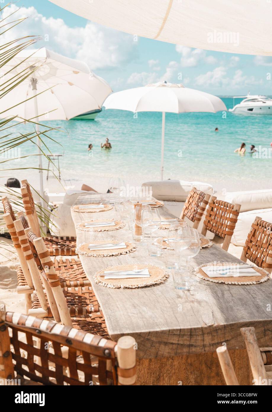 beach club caraibico con tavoli in legno e vista mare turchese Foto Stock