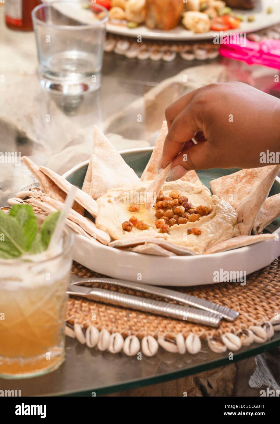 Hummus e piatto di pane in un ristorante sulla spiaggia con tavolo Foto Stock
