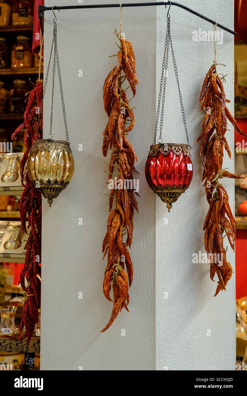 Mercato interno caldo e rustico caratterizzato da numerosi filamenti di peperoncino rosso essiccato appesi a lanterne di vetro dorato e rosso con i Foto Stock