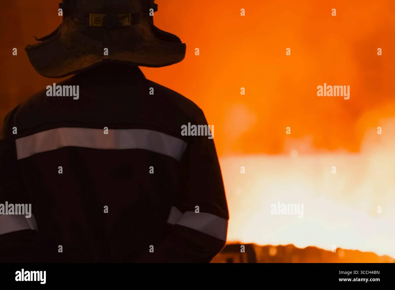 Operatore dell'altoforno che guarda l'acciaio fuso Foto Stock