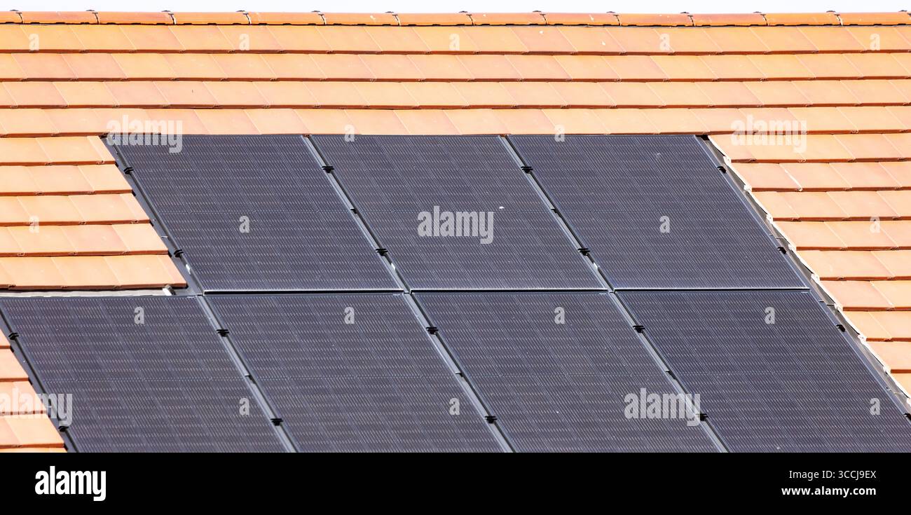 Vista ravvicinata dei pannelli solari installati su un tetto piastrellato per sfruttare l'energia solare rinnovabile Foto Stock