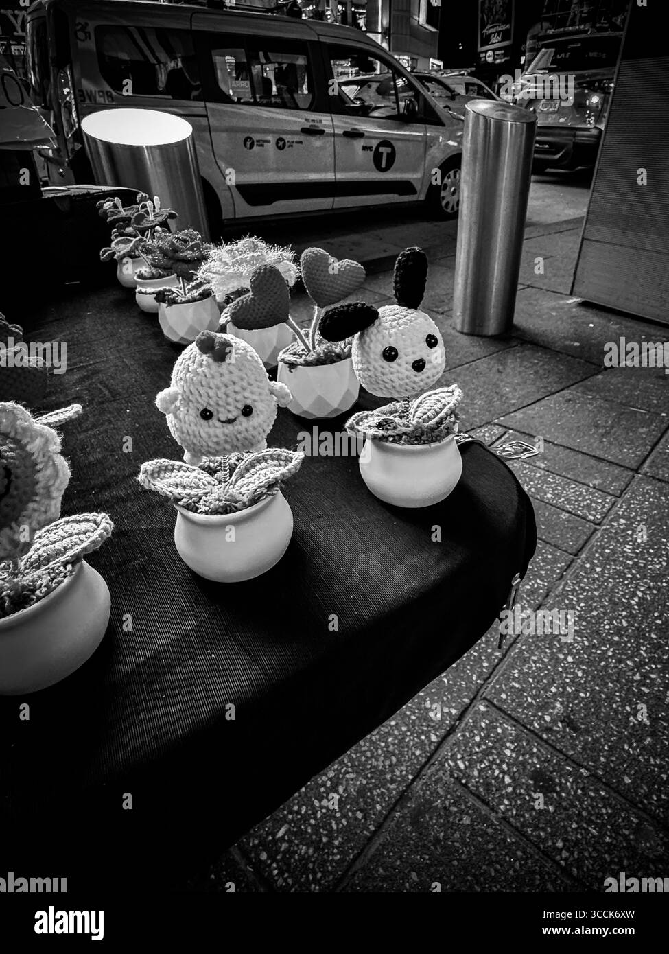 Bambole decorative tessute a mano esposte sul tavolo di un venditore ambulante a Times Square, Manhattan, New York City, fotografate di notte. Foto Stock