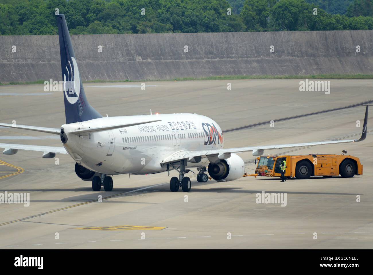 Un aereo passeggeri è stato spinto fuori dal suo parcheggio presso l'aeroporto internazionale Pudong di Shanghai, Cina, l'11 agosto 2025. Foto Stock