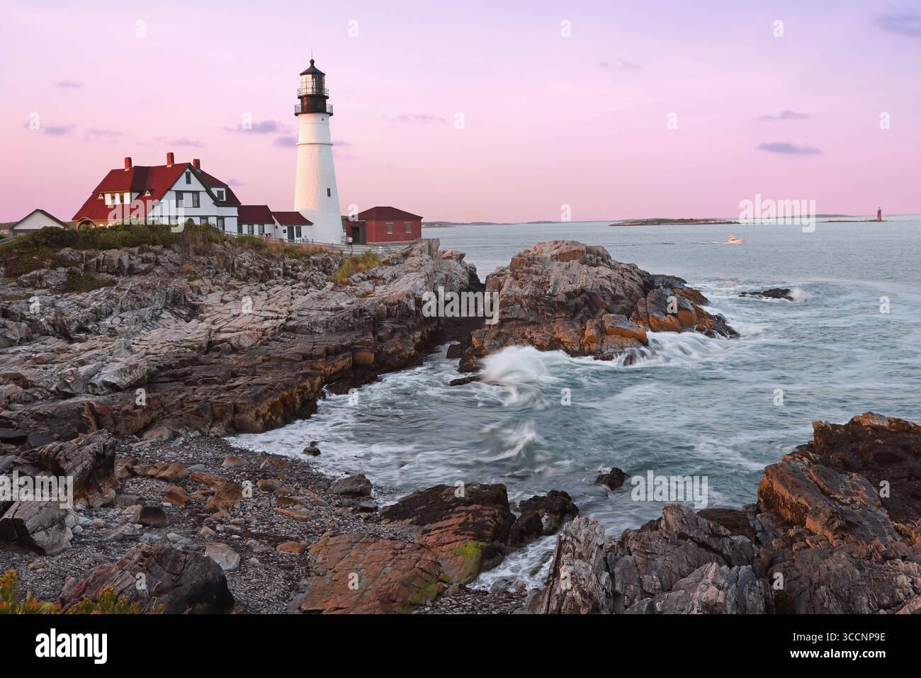 Portland Head Light al tramonto circondato da onde e scogliere spettacolari, Maine, Stati Uniti Foto Stock