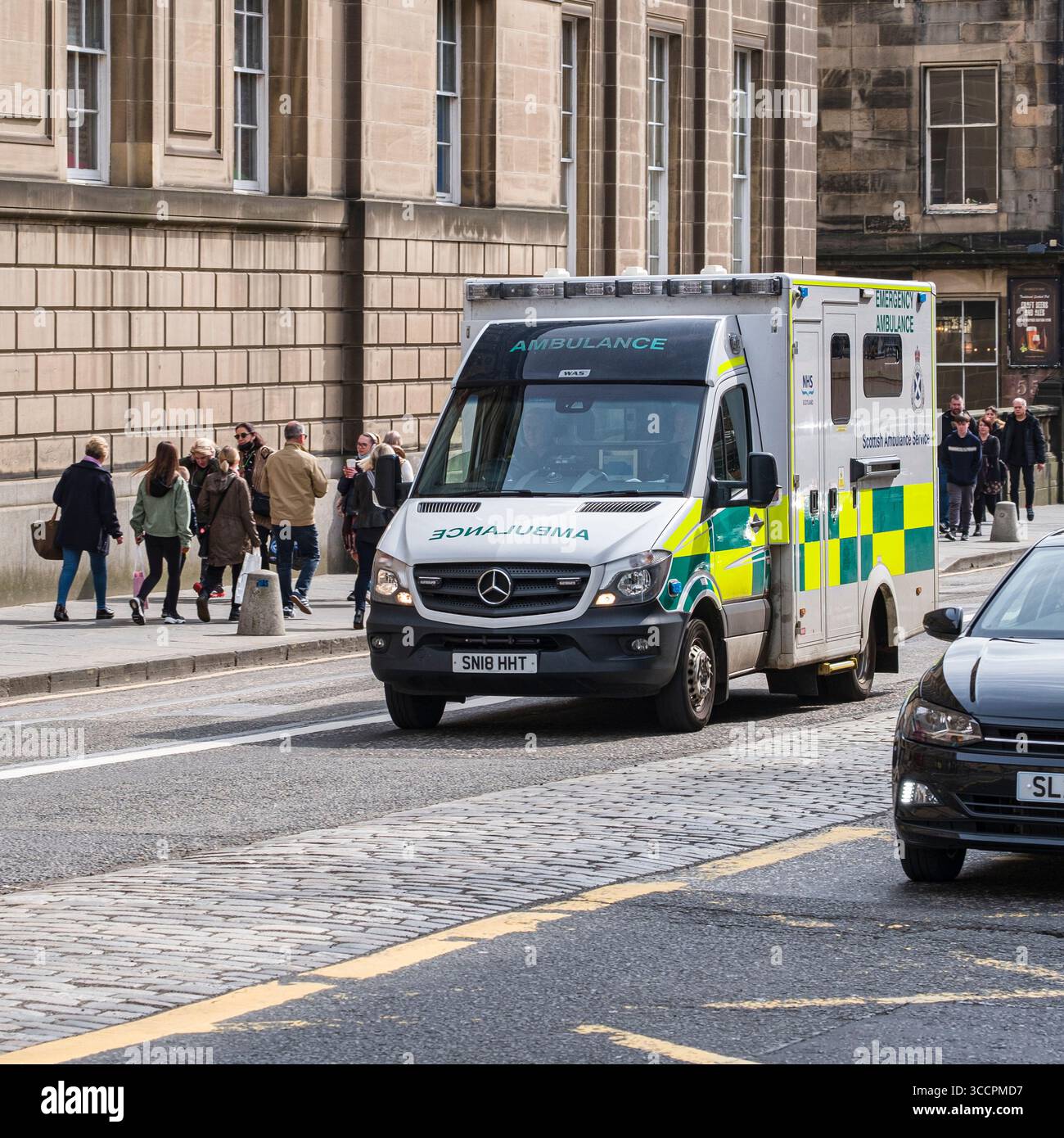Mercedes-Benz Sprinter Box Ambulance of the Scottish Ambulance Service che guida sul Royal Mile, Old Town, High Street, Edimburgo, Scozia, Regno Unito Foto Stock