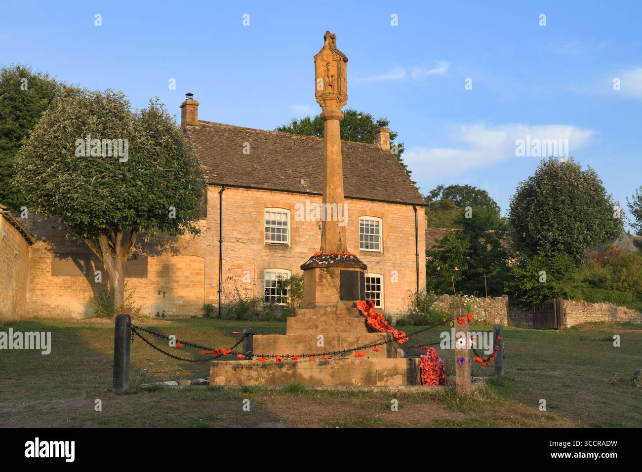 Monumento alla guerra e cottage alla luce del mattino presto all'alba. Guiting Power, Cotswolds, Gloucestershire, Inghilterra Foto Stock