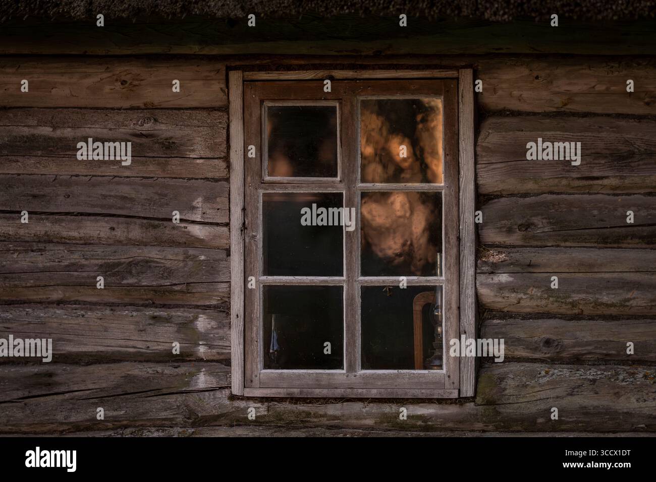 Cabina rustica in legno e finestra con un riflesso dell'alba. Sfondo della vecchia finestra di legno. Foto Stock